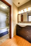 The bathroom is located off of the hall. The vanity is located at the end of the hall, and the shower and toilet have a separate door for added privacy. 